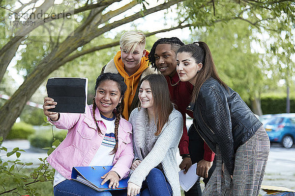 Glückliche Studenten  die ein Selfie mit einem digitalen Tablet im Park machen