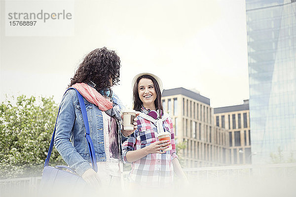 Junge Frauen Freunde mit Kaffee zu Fuß in der Stadt