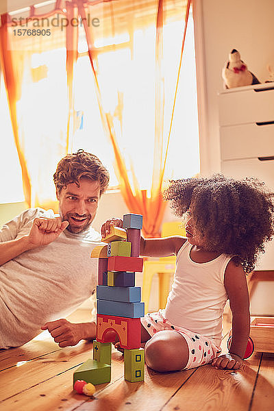 Vater und Tochter spielen mit Holzklötzen