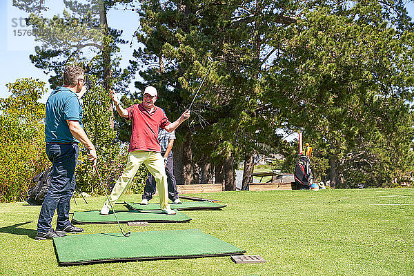 Glücklicher älterer männlicher Golfer  der auf einem sonnigen Golfplatz jubelt