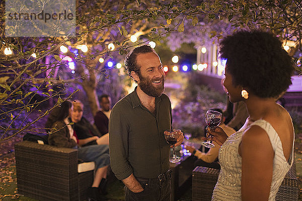 Freunde reden und trinken auf einer Gartenparty