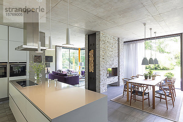 Moderne offene Küche und Esszimmer mit gemauertem Kamin