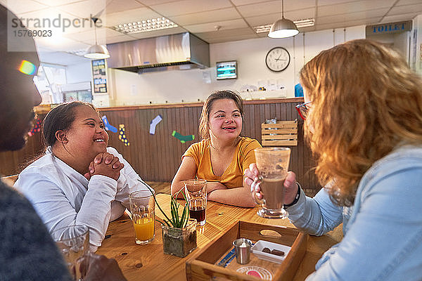 Junge Frauen mit Down-Syndrom im Gespräch mit Mentoren im Cafe