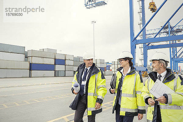 Dockarbeiter und Manager  die auf einer Werft spazieren gehen und sich unterhalten