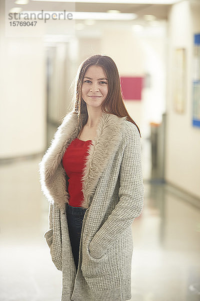 Porträt selbstbewusste junge Studentin im Korridor