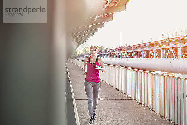 Junge Frau läuft auf dem Bahnsteig einer S-Bahn-Station