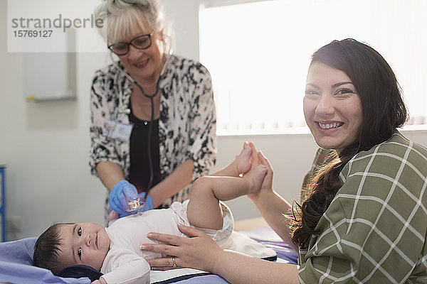 Portrait glückliche Mutter mit kleiner Tochter und Kinderarzt im Untersuchungsraum