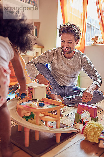 Vater und Tochter spielen mit Spielzeug