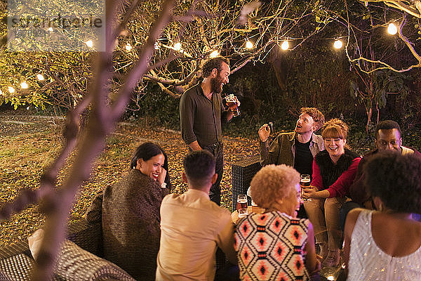 Freunde reden und trinken auf einer Gartenparty