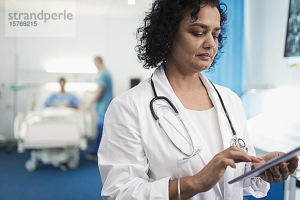 Ärztin mit digitalem Tablet im Krankenhauszimmer