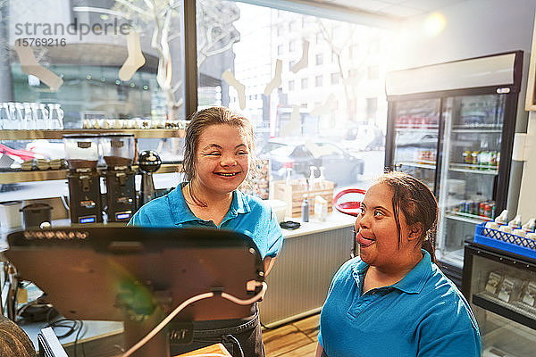 Glückliche junge Frauen mit Down-Syndrom arbeiten in einem Café