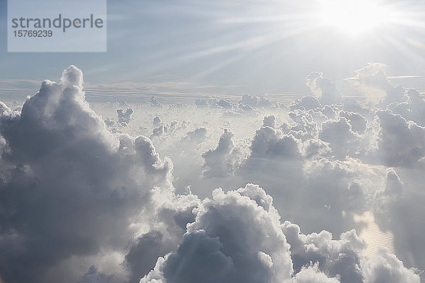 Luftaufnahme Sonnenstrahlen über flauschigen Wolken am Himmel