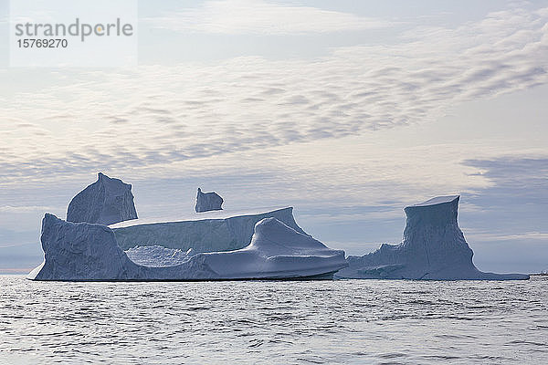 Majestätische Eisbergformationen über dem sonnigen Atlantischen Ozean Grönlands