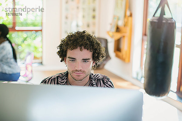 Junger Mann arbeitet am Computer im Heimbüro