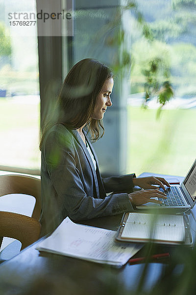Konzentrierte Geschäftsfrau arbeitet am Laptop