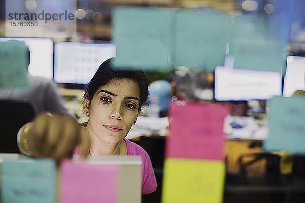 Engagierte Geschäftsfrau mit Haftnotizen bei der Planung im Büro