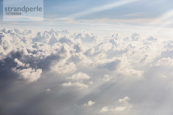 Luftaufnahme Sonnenstrahlen über flauschigen weißen Wolken