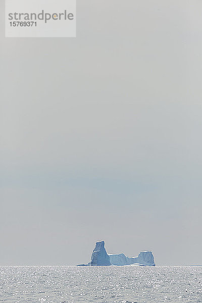 Eisbergbildung in der Ferne auf dem sonnigen Atlantischen Ozean Grönlands