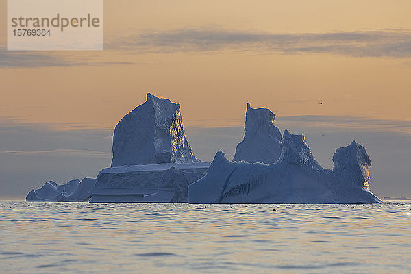 Ruhiger majestätischer Eisberg bei Sonnenuntergang im Atlantischen Ozean Grönland