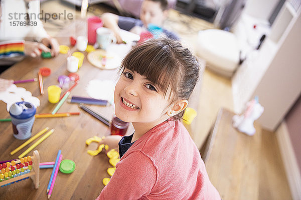 Porträt glückliches begeistertes Mädchen spielt mit Spielzeug am Tisch