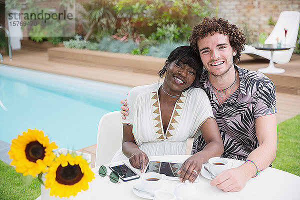 Porträt glückliches junges multiethnisches Paar am Pool