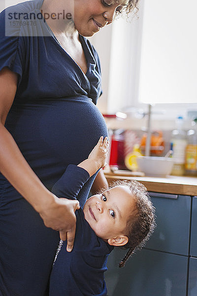 Portrait niedliche Tochter berührt schwangere Mutter Bauch