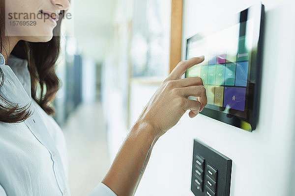 Nahaufnahme einer Frau am Touchscreen der Hausautomatisierung