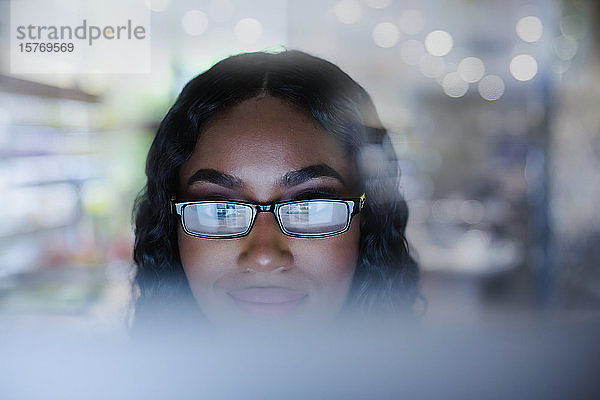 Junge Geschäftsfrau mit Brille arbeitet am Computer