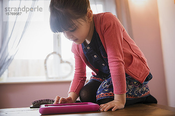 Neugieriges Mädchen mit digitalem Tablet