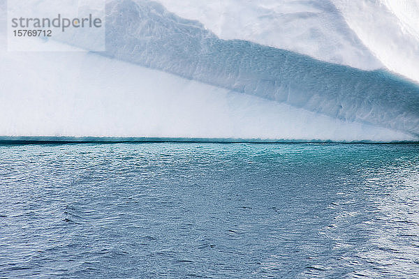 Türkisblaues Meerwasser unter dem Eisberg in Grönland