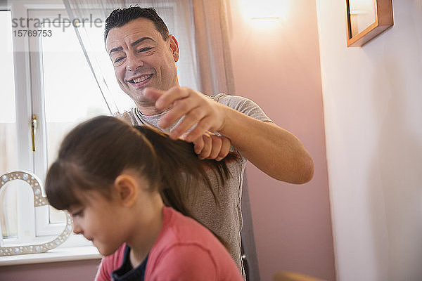 Junge bürstet die Haare seiner Tochter im Badezimmer