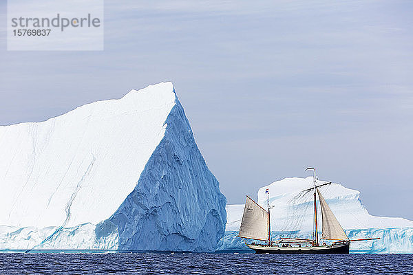 Schiff fährt an majestätischen Eisbergen auf dem Atlantik vorbei Grönland