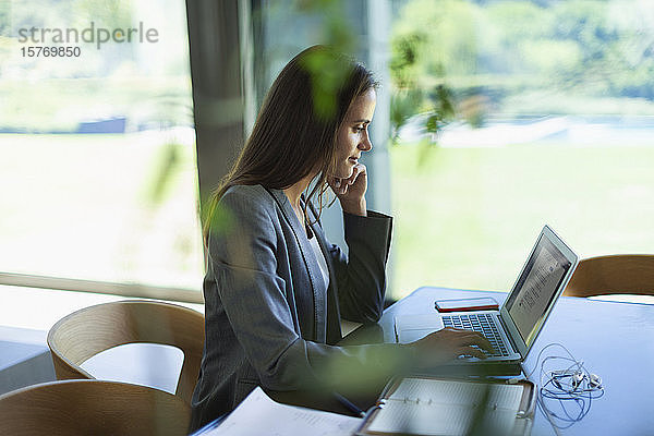 Geschäftsfrau arbeitet von zu Hause aus am Laptop