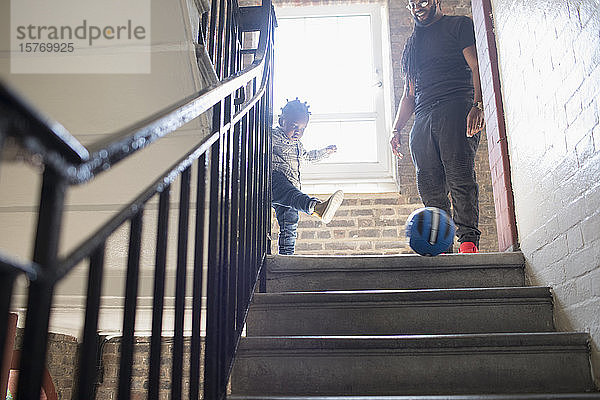 Vater und Kleinkind Sohn spielen mit Fußball auf Treppenabsatz