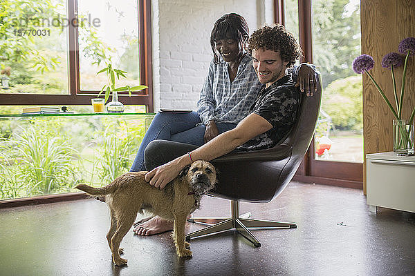 Glückliches junges Paar mit Hund im Heimbüro