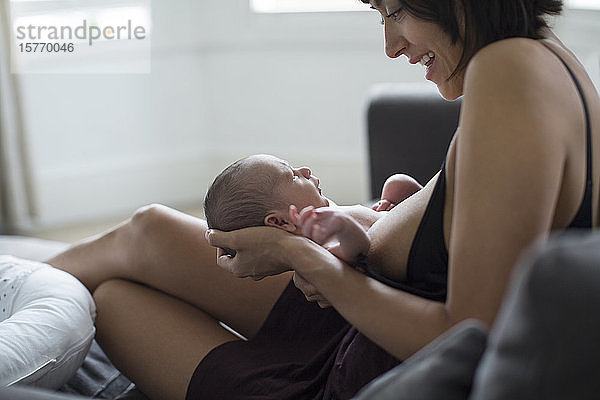 Mutter hält und stillt ihr neugeborenes Baby