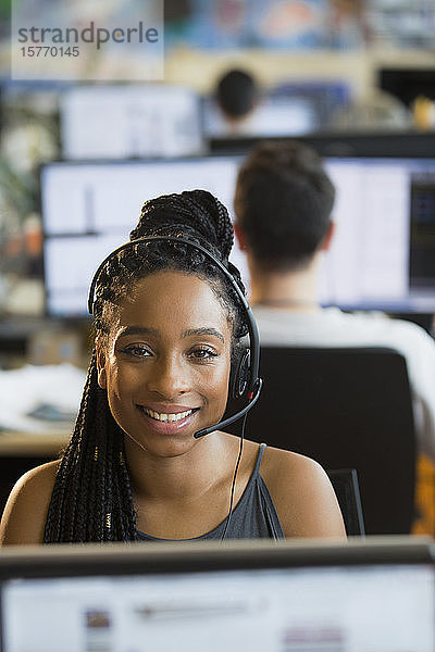 Porträt einer selbstbewussten  lächelnden Geschäftsfrau mit Headset bei der Arbeit im Büro