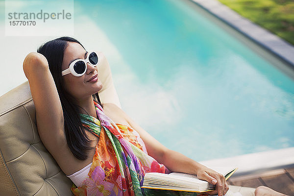 Gelassene Frau entspannt sich  liest ein Buch am Sommerpool