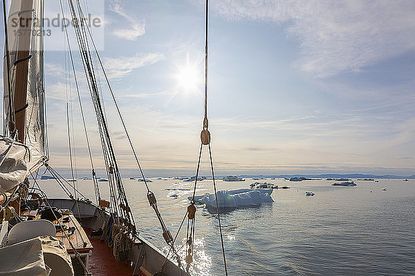 Schiff im schmelzenden Polareis auf dem sonnigen Atlantik in Grönland