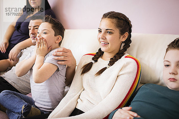 Glückliche Familie beim Fernsehen auf dem Wohnzimmersofa