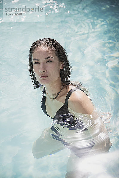 Porträt selbstbewusste Frau schwimmen in sonnigen Sommer Schwimmbad