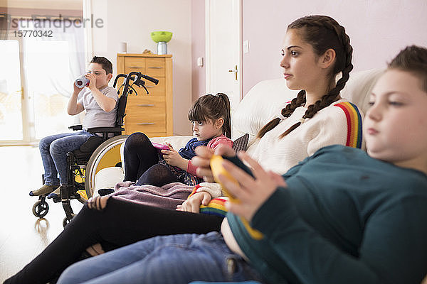 Geschwister beim Fernsehen auf dem Sofa