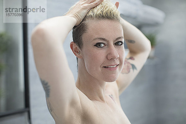 Porträt selbstbewusste schöne Frau mit Tattoos im Badezimmer