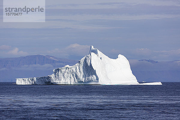 Majestätische Eisbergformation über dem sonnigen blauen Atlantischen Ozean Grönlands