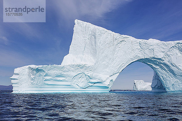 Majestätischer Eisbergbogen über dem sonnigen Atlantik in Grönland