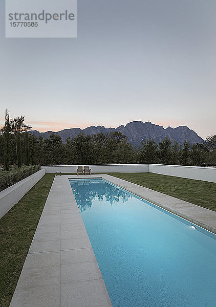 Luxuriöser Pool mit Blick auf die Berge in der Abenddämmerung