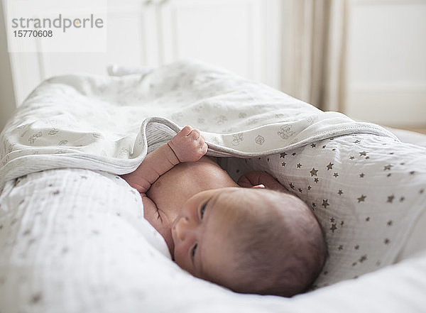 Neugeborenes Baby im Stubenwagen liegend