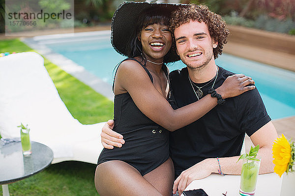 Portrait glückliches junges multiethnisches Paar entspannt am Pool