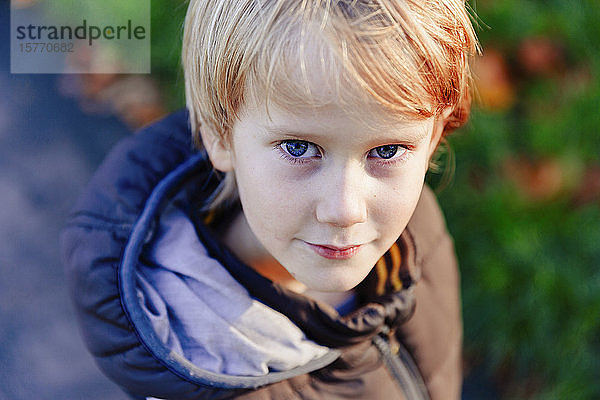 Porträt selbstbewusster Junge mit blondem Haar und blauen Augen