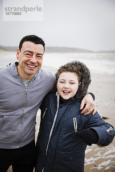 Portrait glücklicher Vater und Sohn am Strand